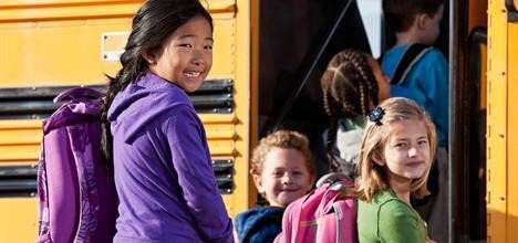 Children getting on a school bus.