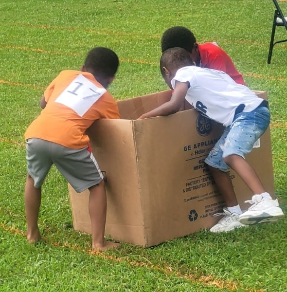 Children reaching into a large cardboard box.