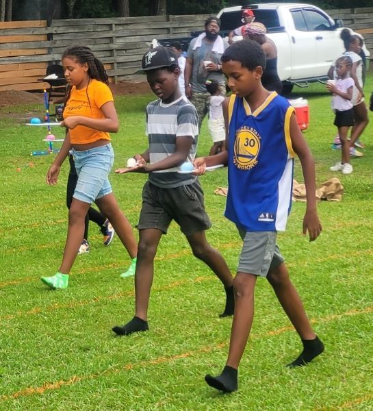 Boys and girls racing with an egg on a spoon.