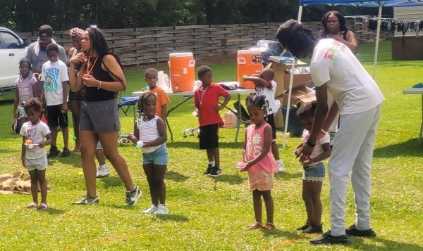 Children lined up to run a race with eggs and spoons. 