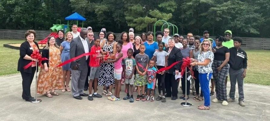 A group of people at the ribbon cutting ceremony for the new playgrounds.