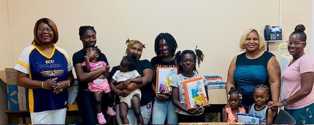 A group of parents and children who received school supplies.
