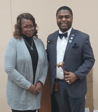 Gwen Wynn with gentleman who is holding a gavel, smiling