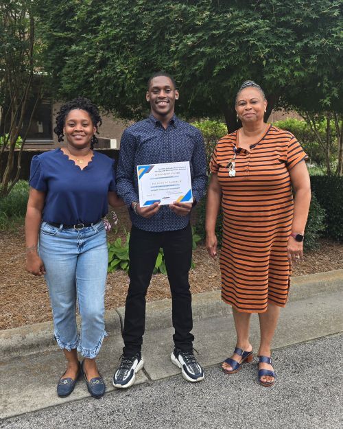 James Sanders Jr. Smiling holding his scholarship.