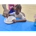  An adult helping a young child mixing stuff in a bowl. 